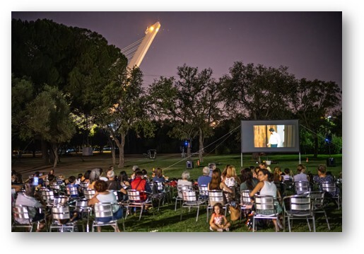 large group enjoying movie night outside, representing family-friendly silent auction basket ideas for school and community fundraisers